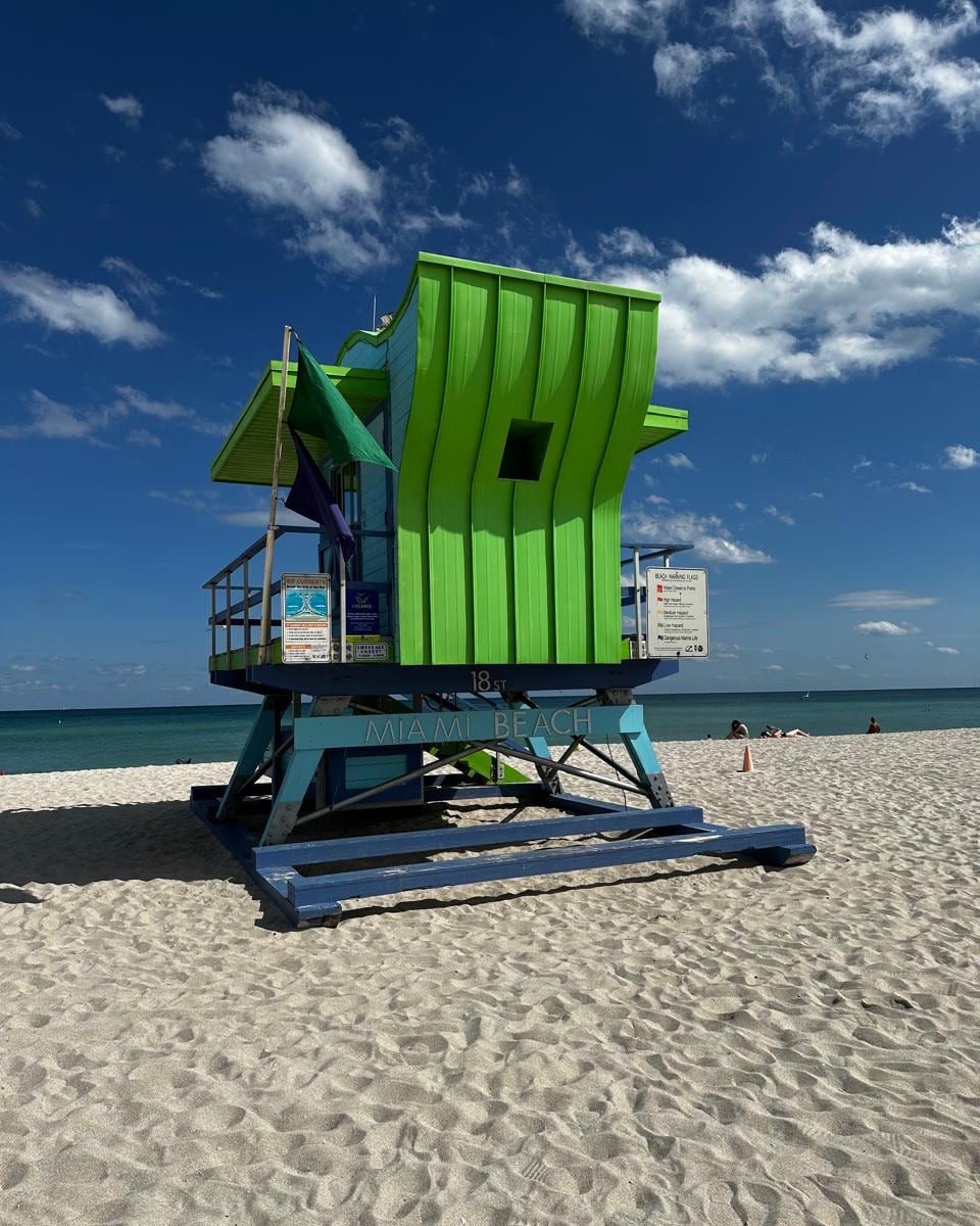 Posto de salva-vidas verde e azul na areia de Miami Beach