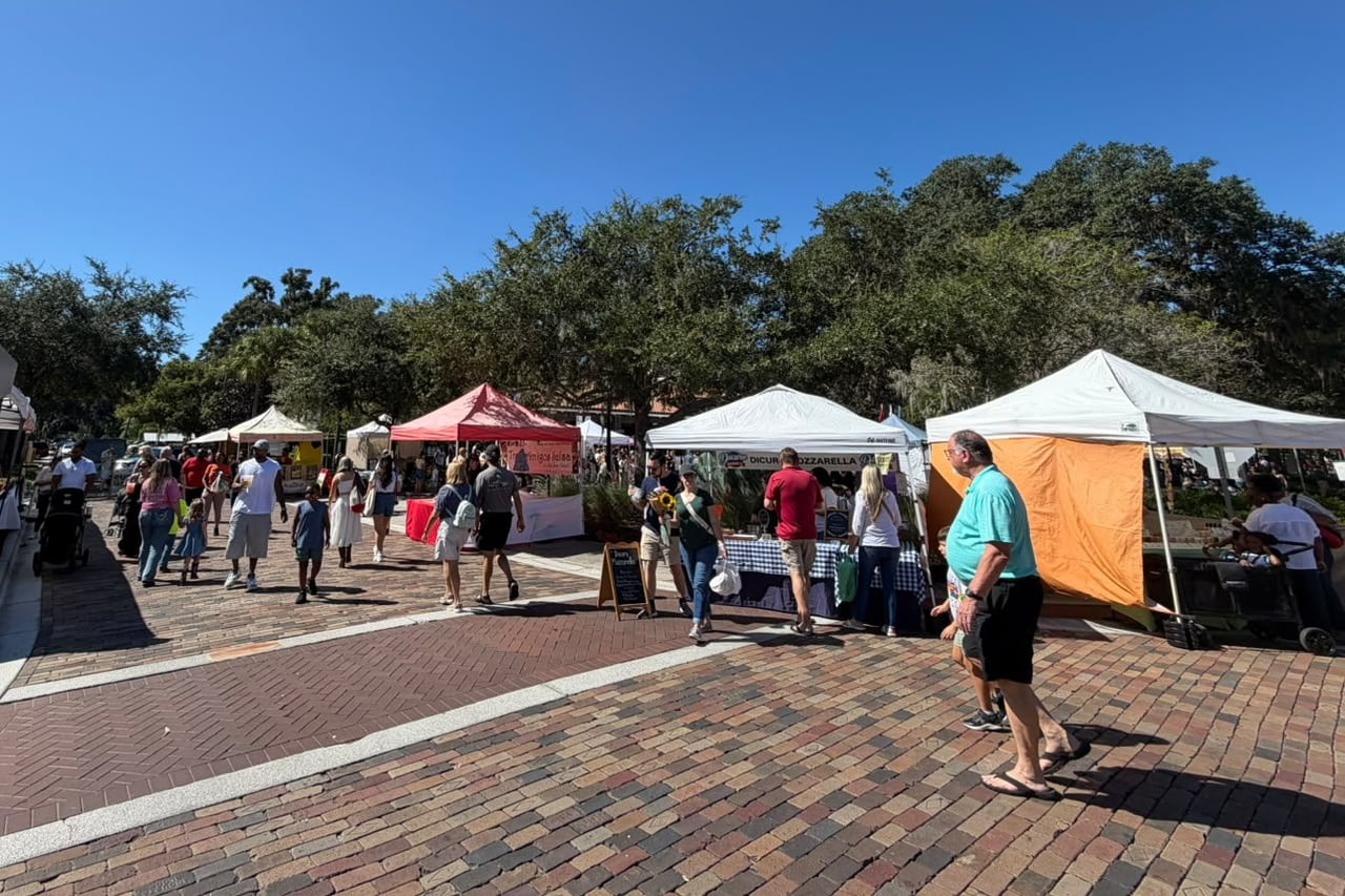 Barracas da feira de sábado de Winter Garden, com gente passeando sob as árvores